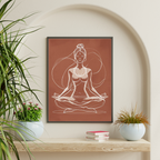 Framed artwork of a woman in a meditative pose on a wall with plants and books below.