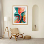 Colorful abstract art in a wooden frame on a wall above a wicker chair.