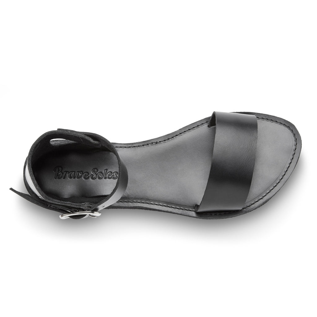 Black sandal with a strap on a white background