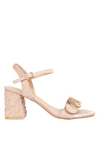 Pink high-heeled sandal with floral design on a light gray background