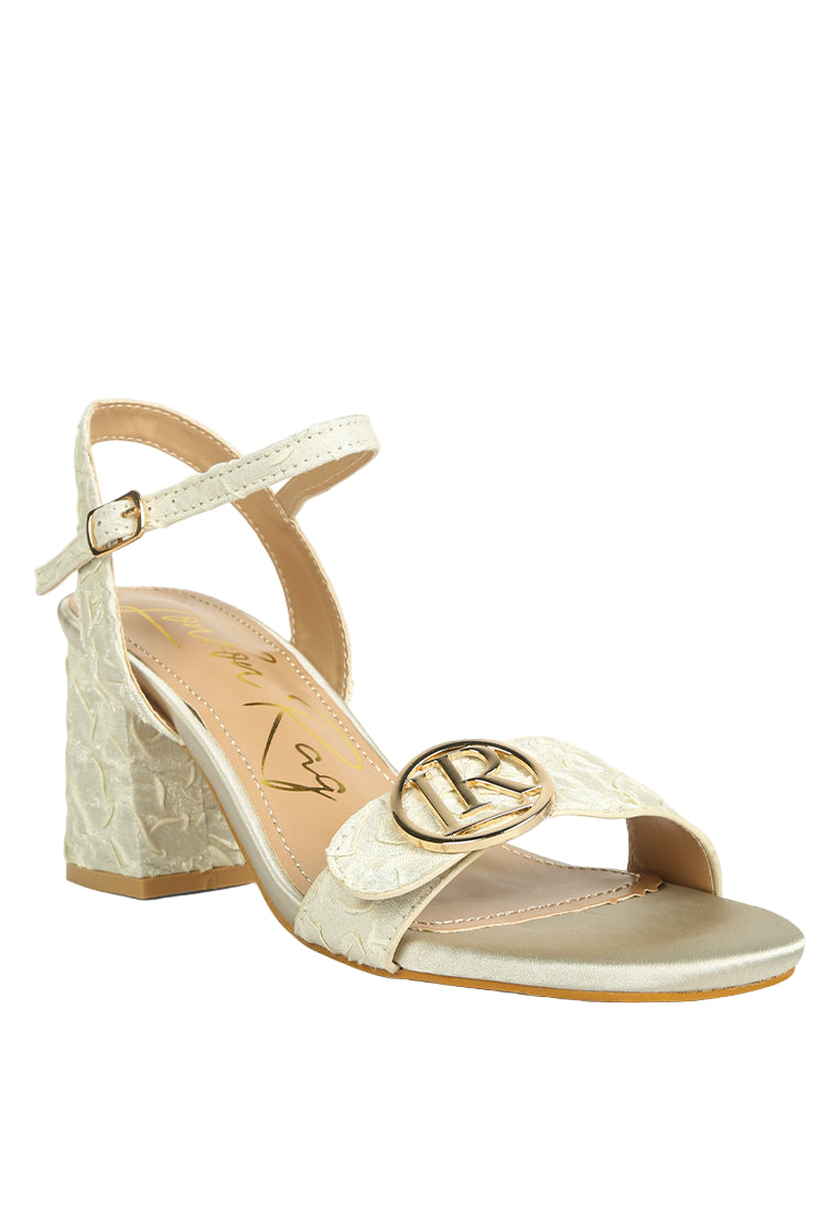 Gold sandal with block heel on a white background