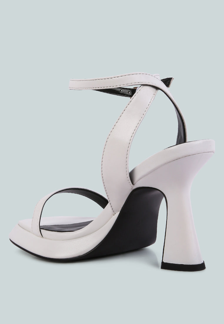 White high-heeled sandal with a black sole on a light blue background