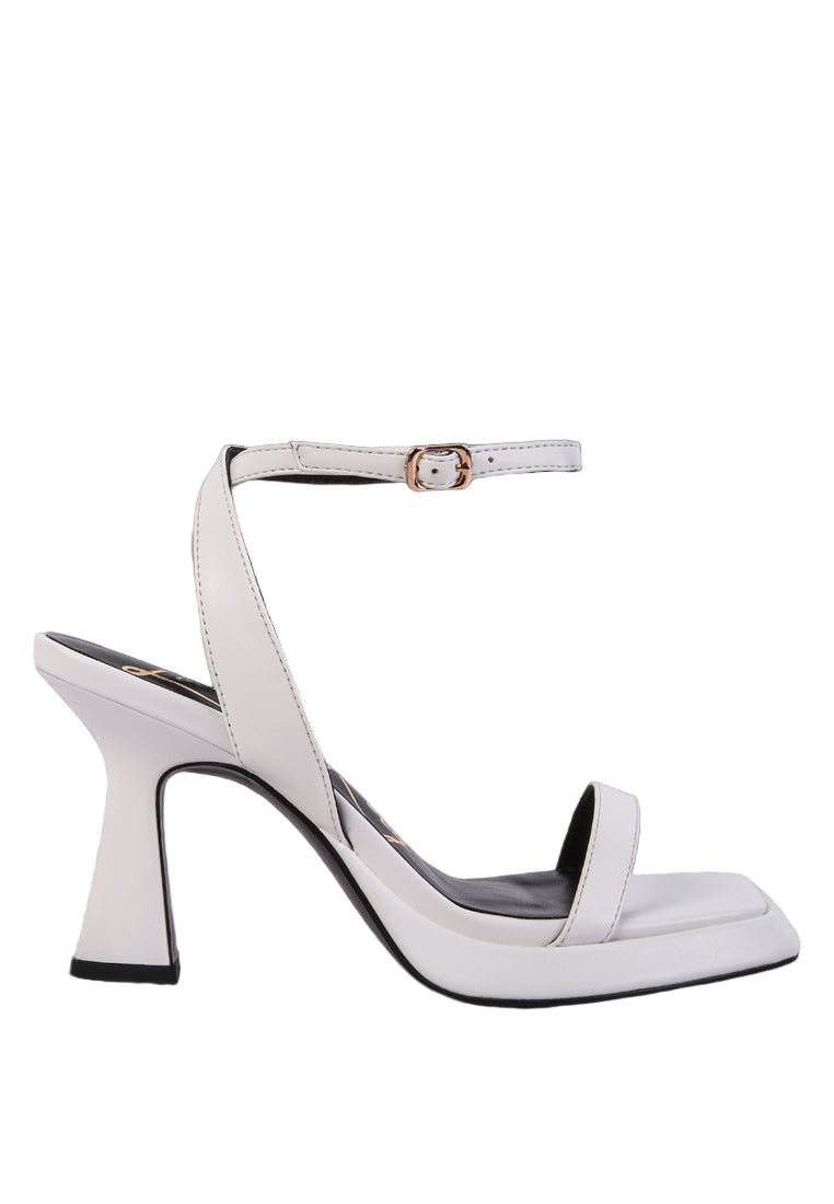 White high-heeled shoe with a thin strap on a light blue background