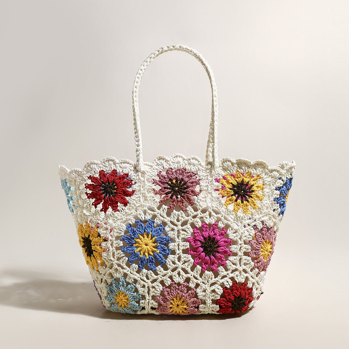 Crocheted bag with colorful floral patterns on a light background