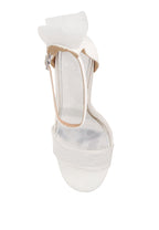 White sandal with a bow on a light gray background