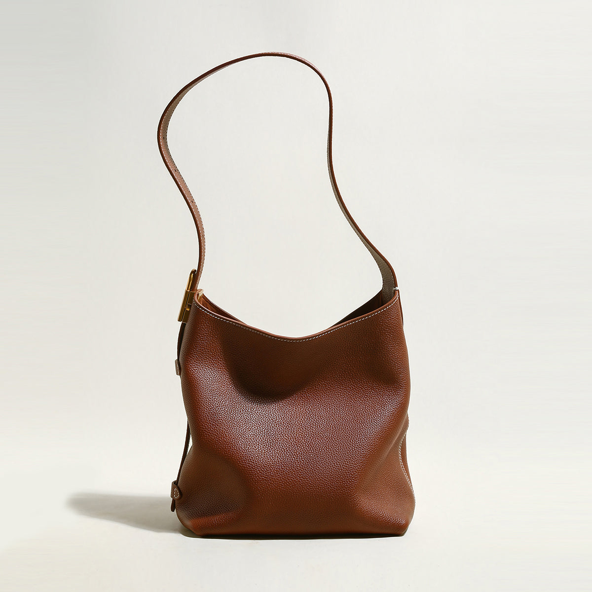 Brown leather handbag on a light beige background
