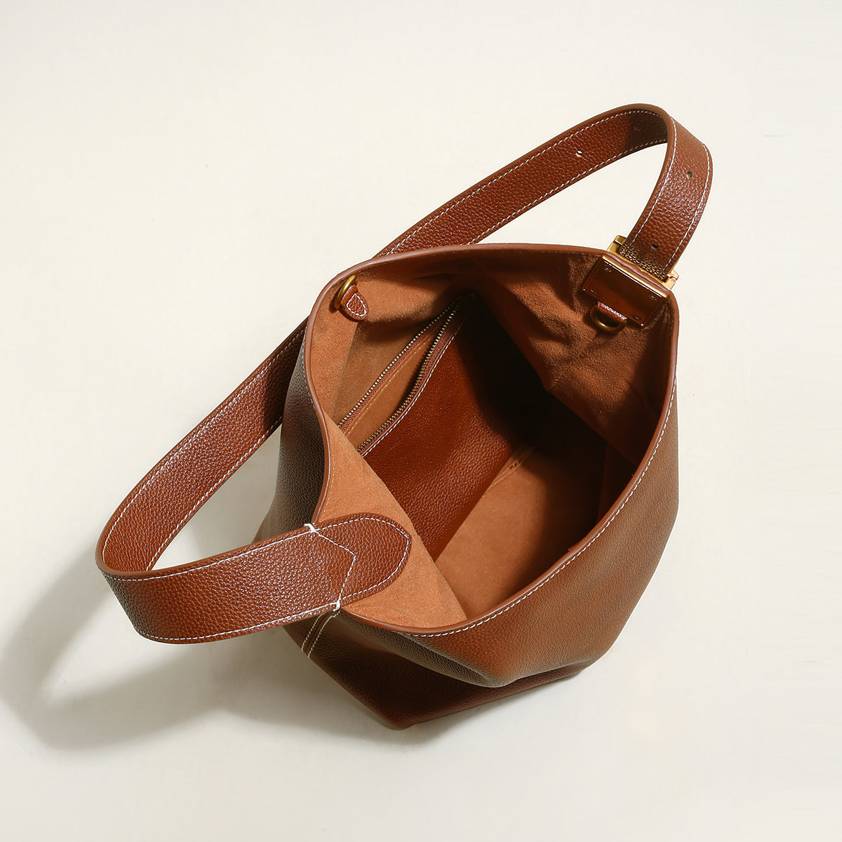 Brown leather handbag on a light beige background