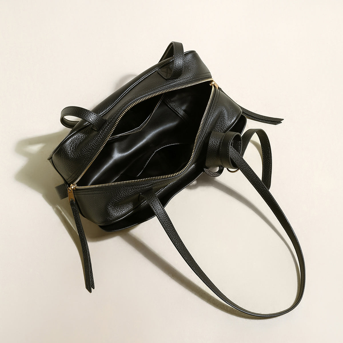 Open view of a stylish black leather Mini Rectangular Knot Strap Shoulder Bag showcasing interior compartments.