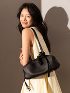 Model wearing a black Mini Rectangular Knot Strap Shoulder Bag with a vintage bowling silhouette.
