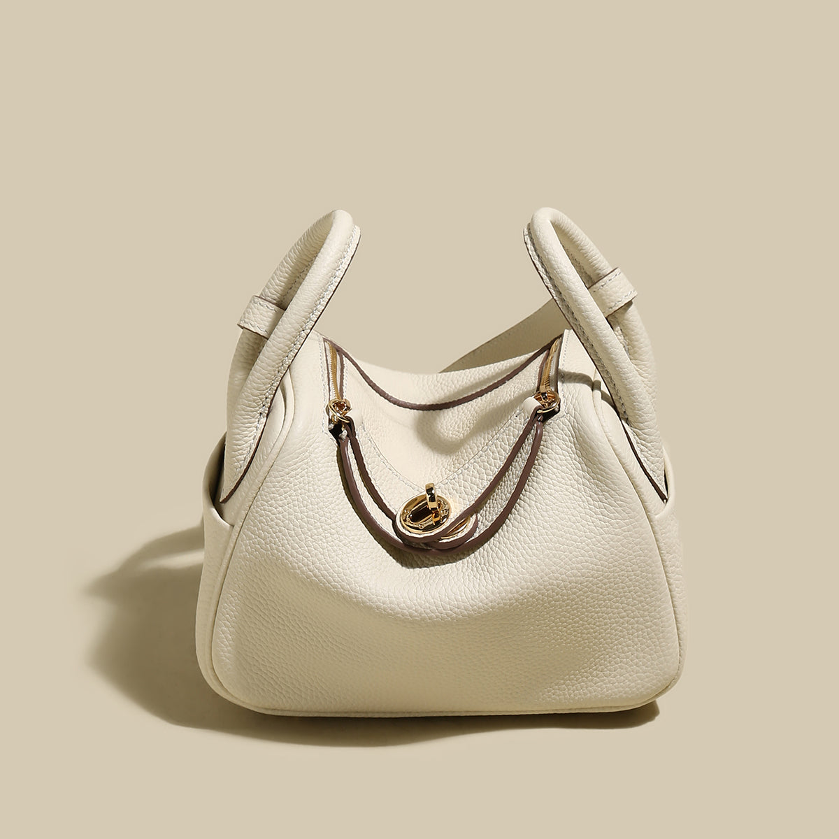 Monte Convertible Shoulder Bag in cream color with gold hardware and unique handle design.