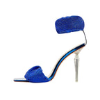 Blue high-heeled shoe with clear heel on a white background