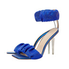Blue high-heeled sandal with clear heel on a white background