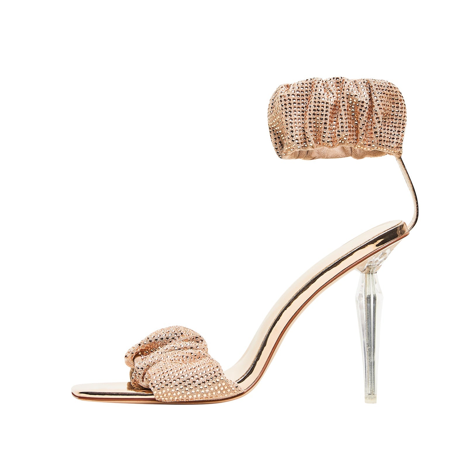 Gold high-heeled sandal with clear heel on a white background