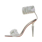 High-heeled shoe with crystal embellishments on a white background