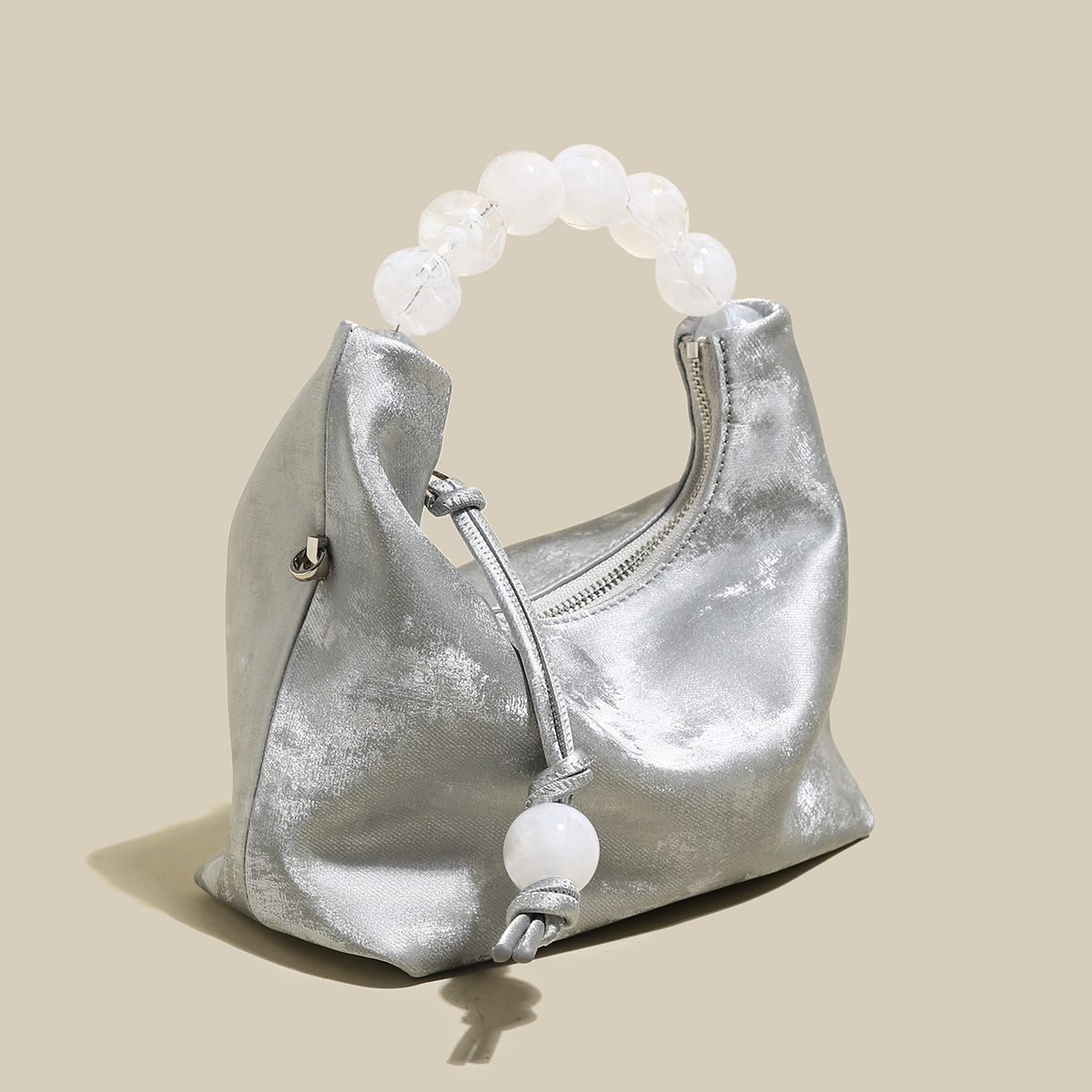 Silver pearl top handle bag with oversized pearl handle, perfect for chic occasions and evening events.