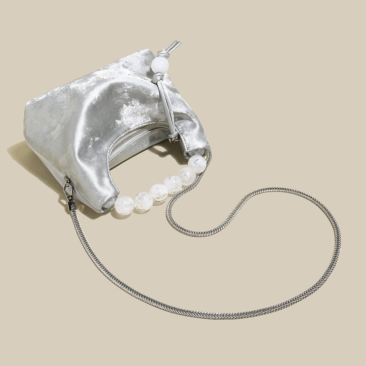 Elegant silver pearl top handle bag featuring a luxurious velvet finish and oversized pearl handle, perfect for chic occasions.