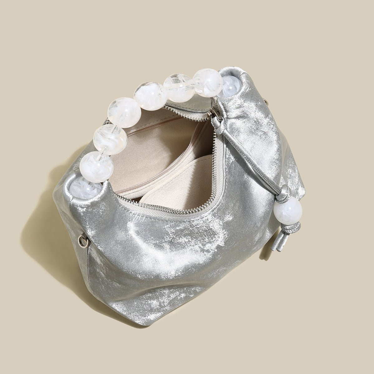 Stylish silver pearl top handle bag with oversized pearl handle, perfect for chic occasions and evening events.