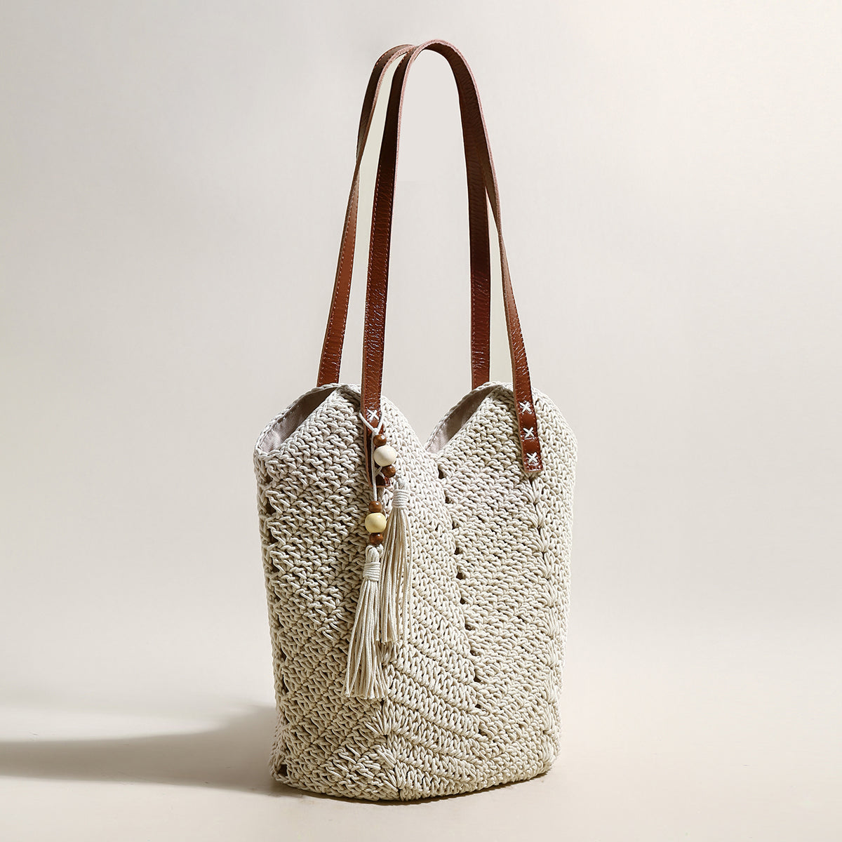 Crocheted bag with brown straps on a light background
