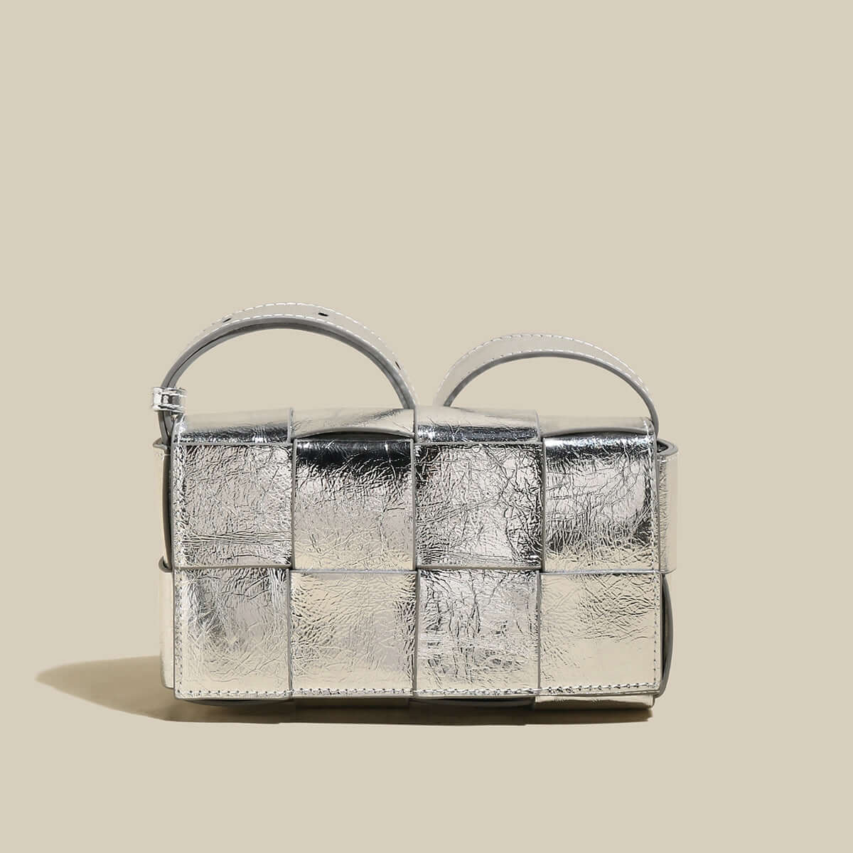Silver textured handbag on a beige background