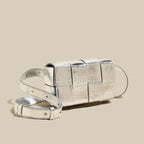 Silver clutch bag with a strap on a beige background